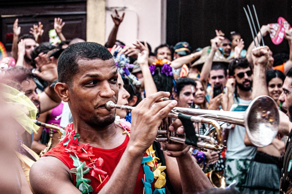 Homem tocando instrumento no carnaval. 