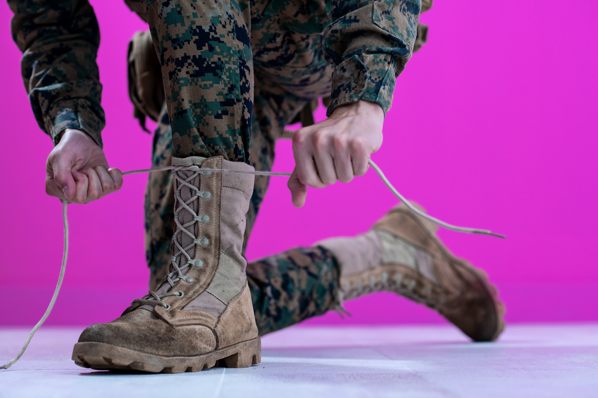 Militar calçando botas