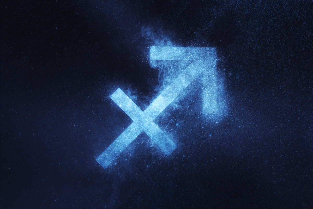 Flecha símbolo de Sagitário formada em céu noturno, com nébula azul e estrelada.