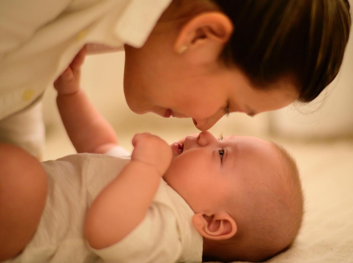 Mãe encostando o nariz em filho bebê.