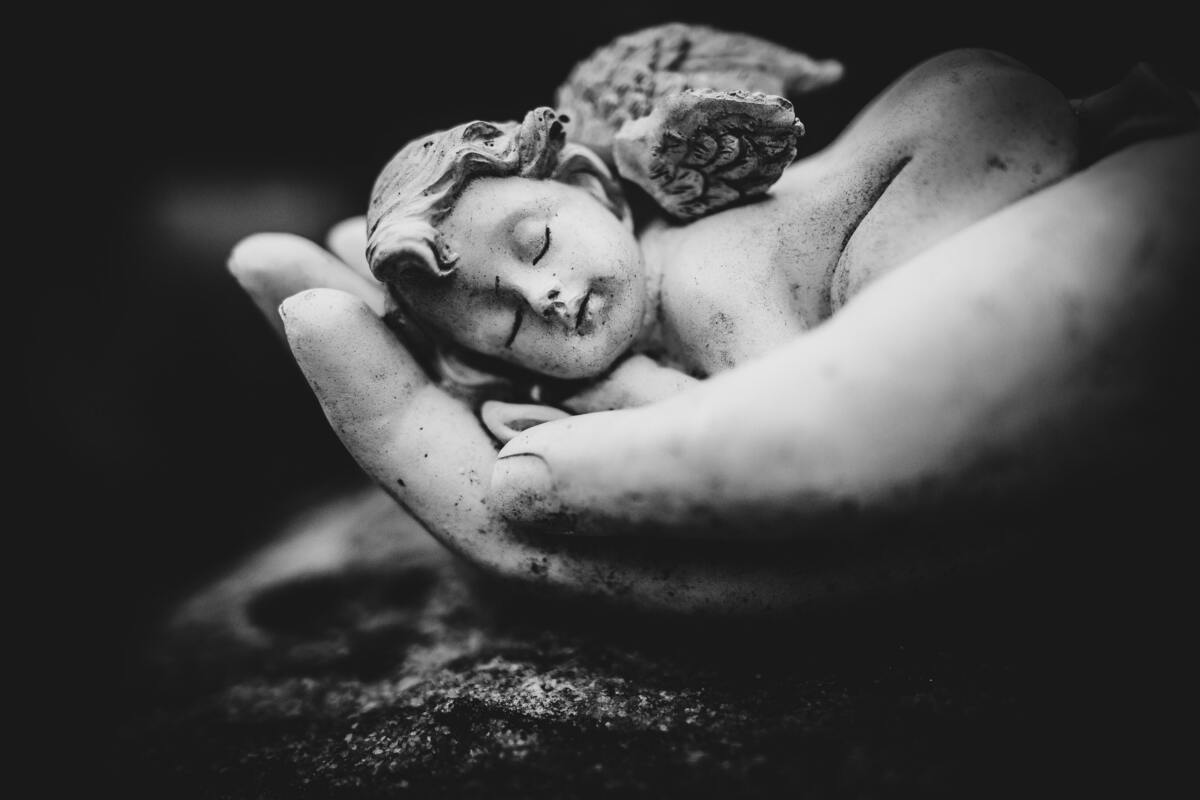 Estátua de pequeno anjo bebê em uma mão