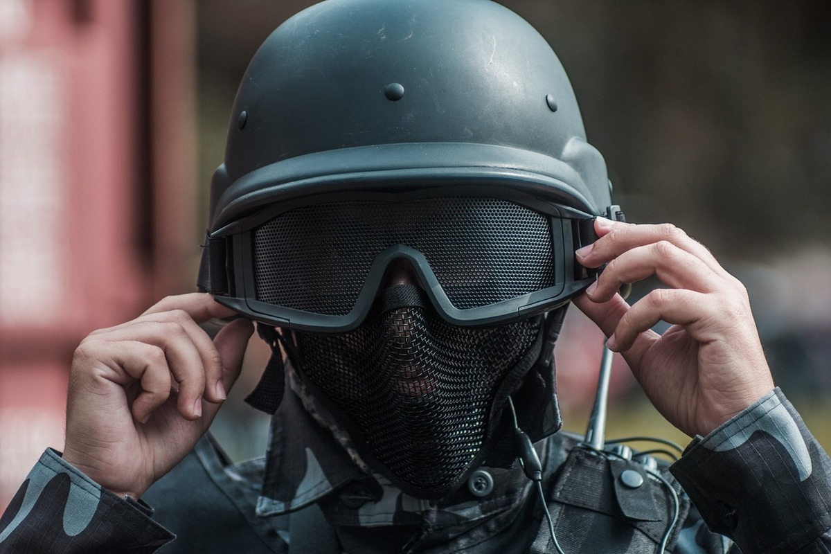 Pessoa usando capacete preto, rede e óculos.
