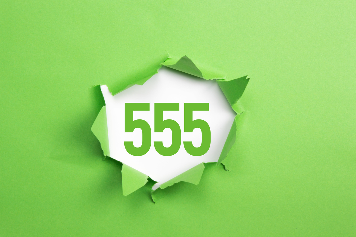 Parede em verde rasgada, revelando o número 555 logo atrás.