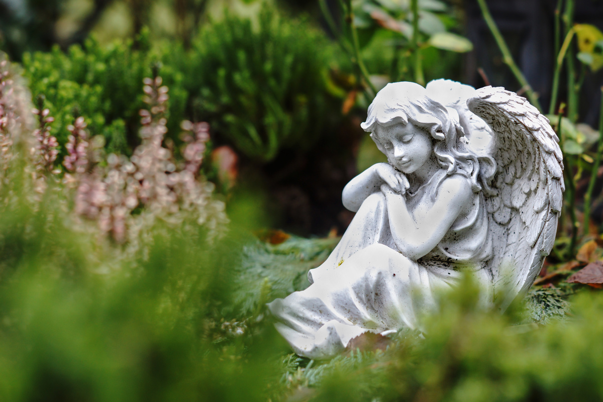 Jardim com estátua de anjo da guarda.