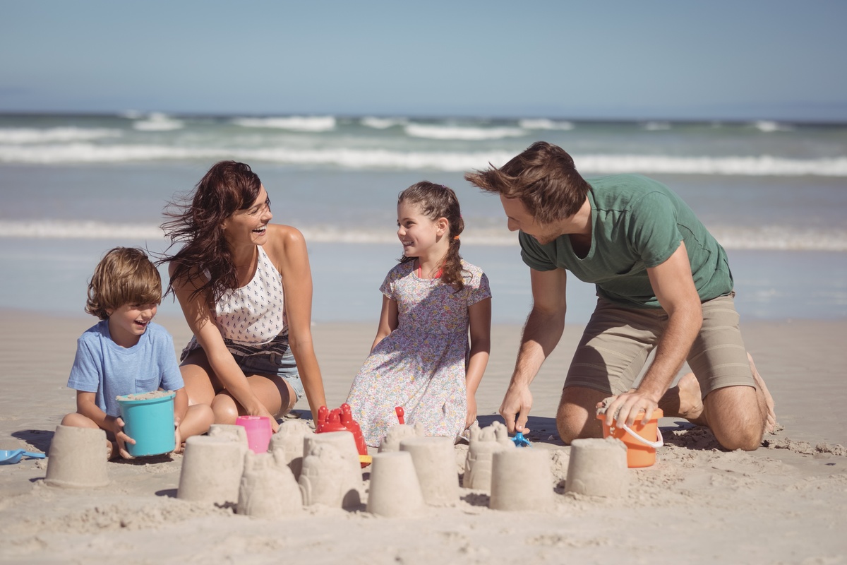 Família construindo castelo de areia