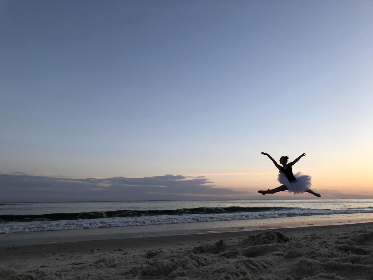 Bailarina dando um salto na praia.