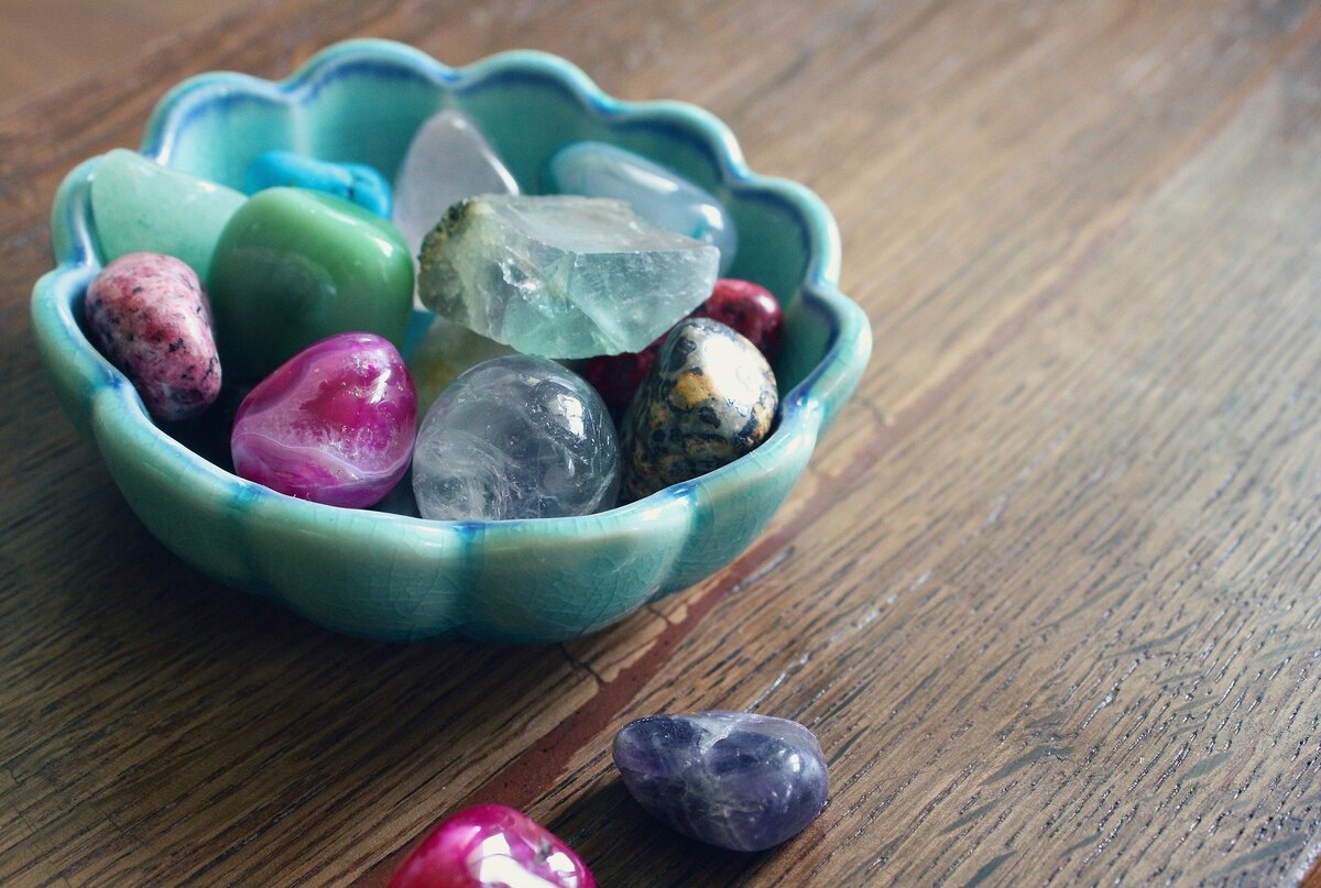 Pequeno recipiente com cristais de diversas cores e tamanhos.