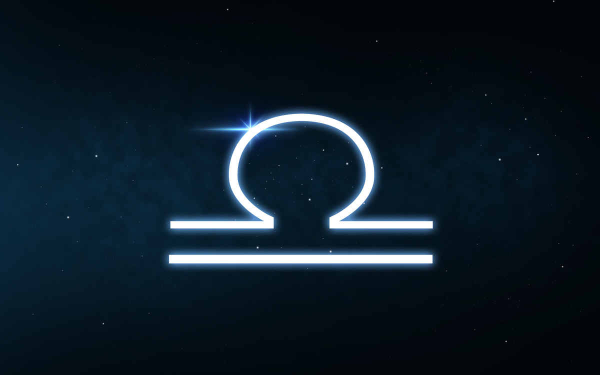 Símbolo do signo de Libra feito em traço azul-claro e iluminado, em fundo do céu azul-escuro e estrelado.