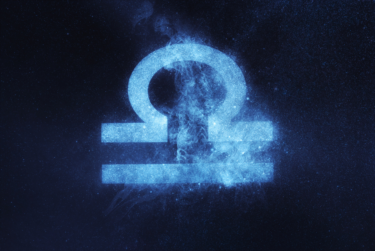 Símbolo do signo de Libra feito em traço azul-claro, iluminado e brilhoso, em fundo do céu azul-escuro e estrelado.