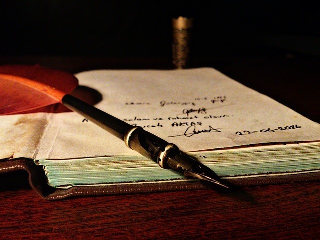 Caderno velho e caneta de pena