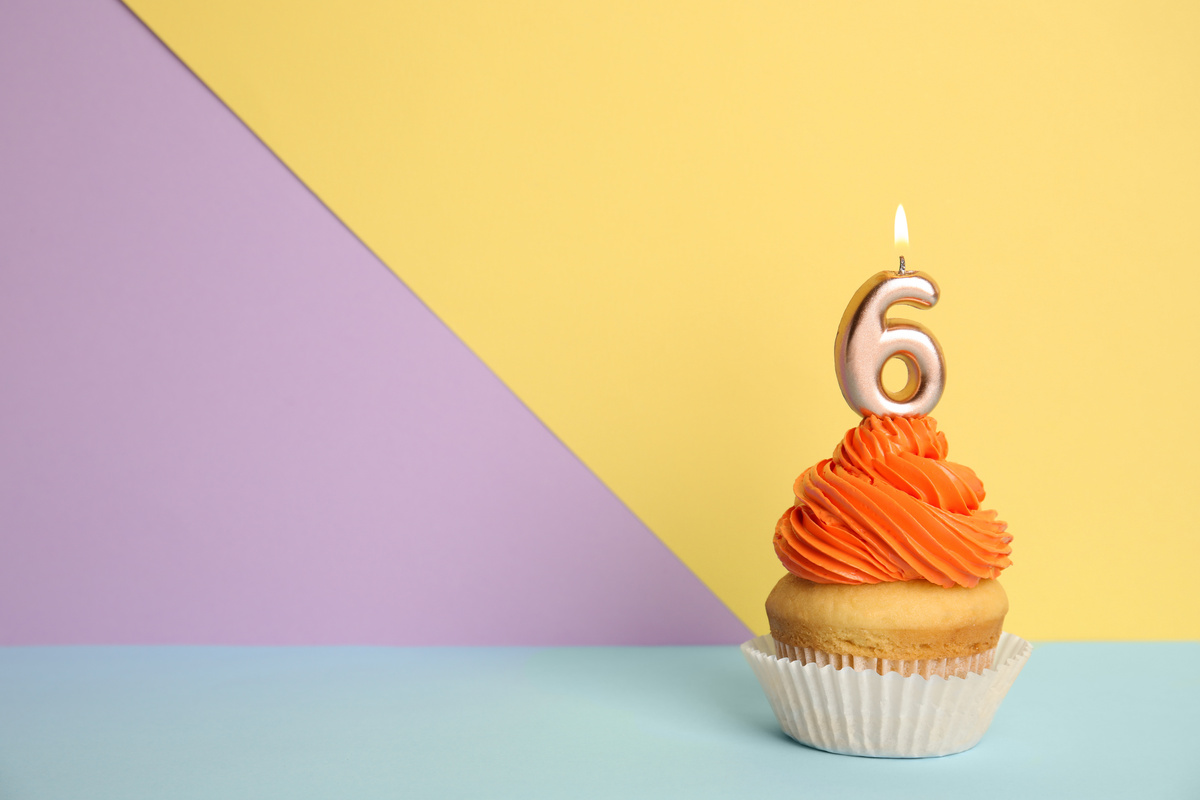 Vela acesa de número 6 em cima de cupcake, representando o nascimento do ano pessoal.