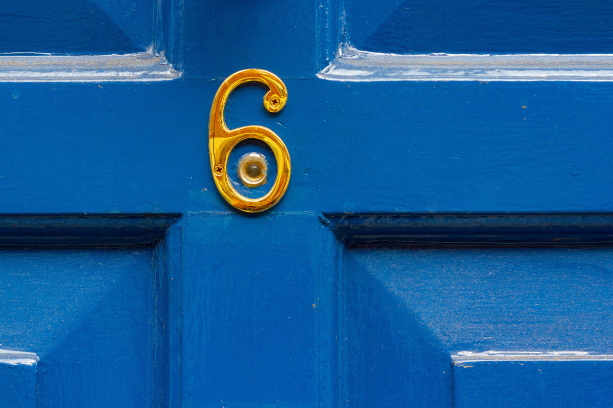 Número 6 dourado estampado em porta azul.