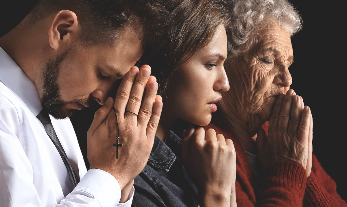 Homem, mulher e idosa orando