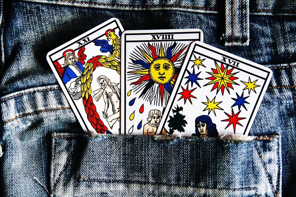 Três cartas de Tarot em bolso de calça jeans.