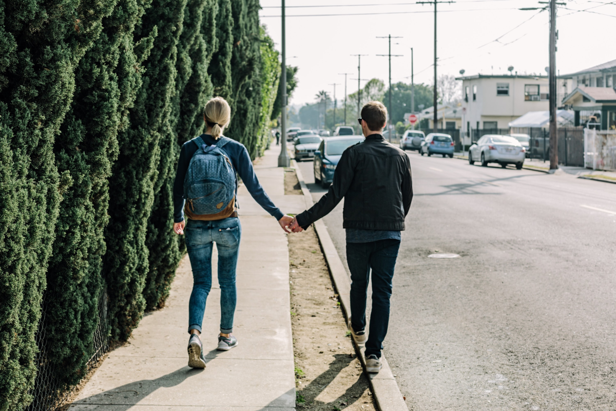 Casal caminhando em rua de mãos dadas