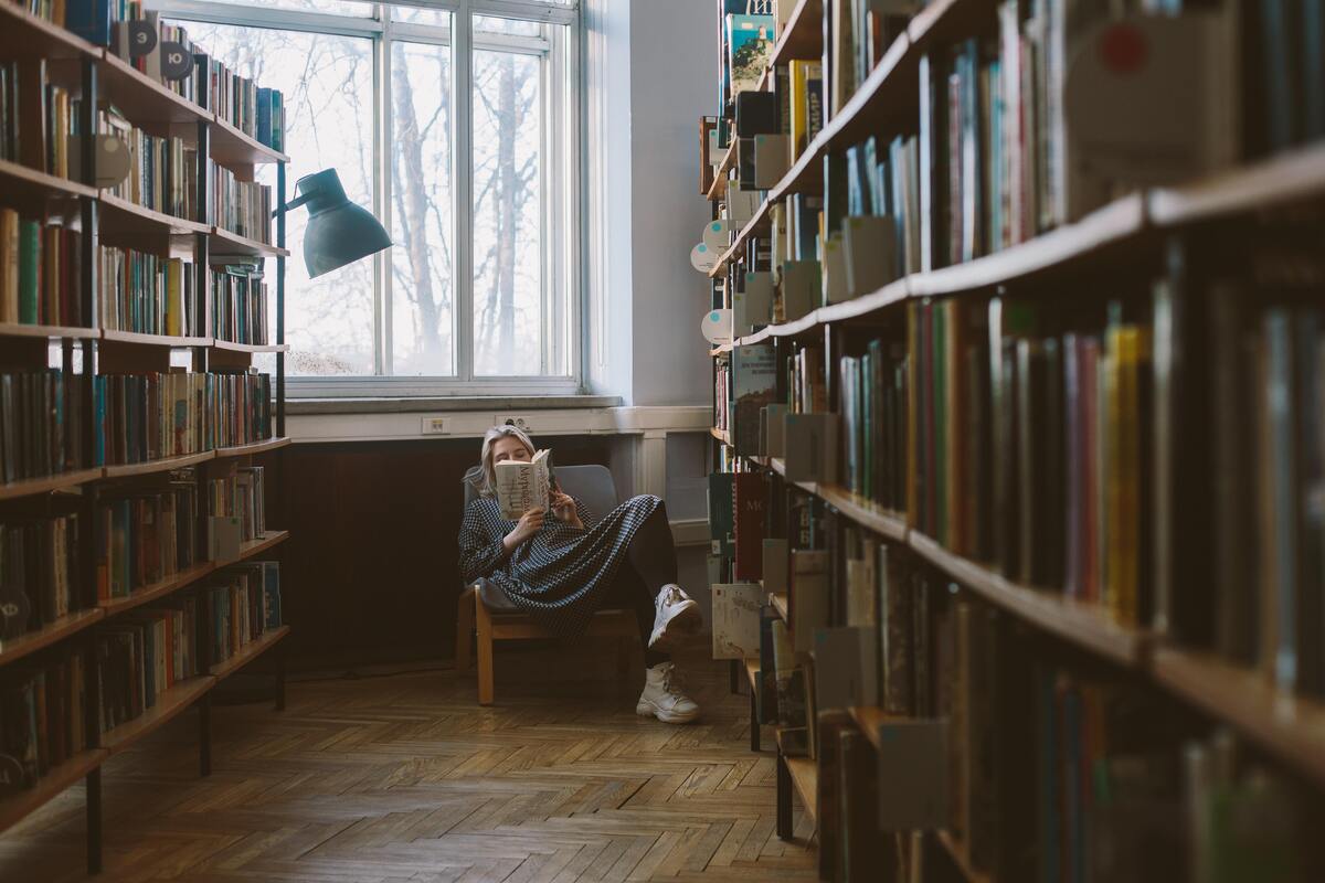 Mulher lendo em biblioteca
