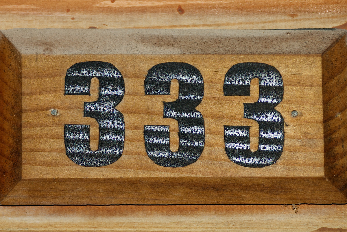 Número 333 marcado em madeira.