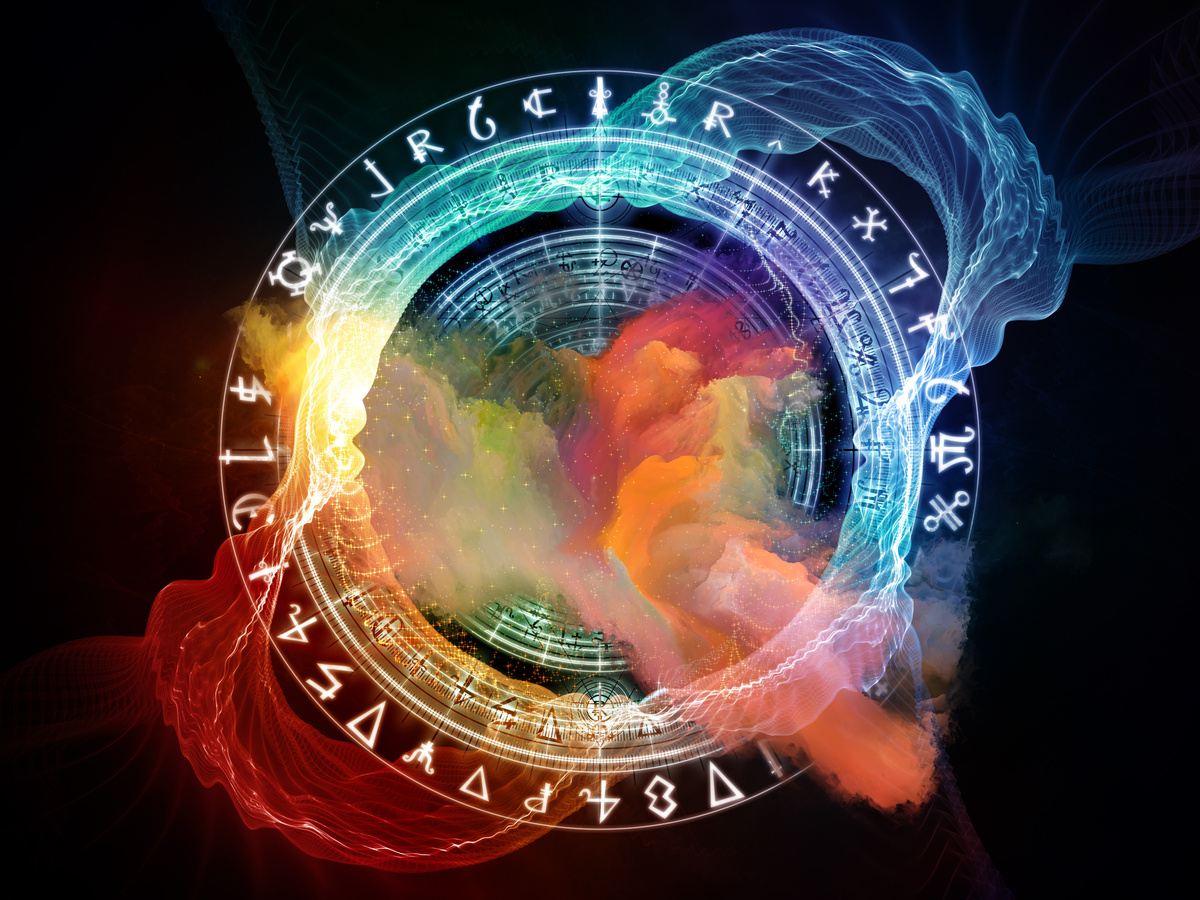 Roda do mapa astral em fundo escuro, rodeada por luzes das cores dos elementos dos signos do Zodíaco: laranja para o elemento ar, vermelho para fogo, azul para água e verde para terra.