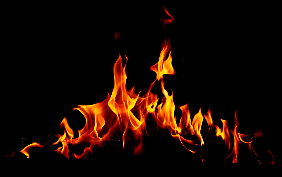 Fogo aceso com chamas vermelhas em ambiente escuro, representando o elemento Fogo.