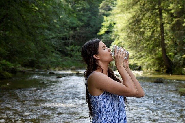 Mulher bebendo água corrente