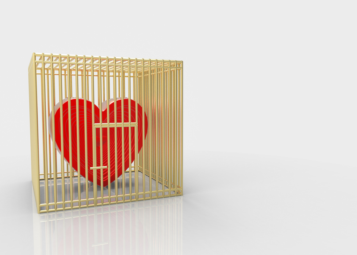 Coração vermelho dentro de uma gaiola representando amarração amorosa