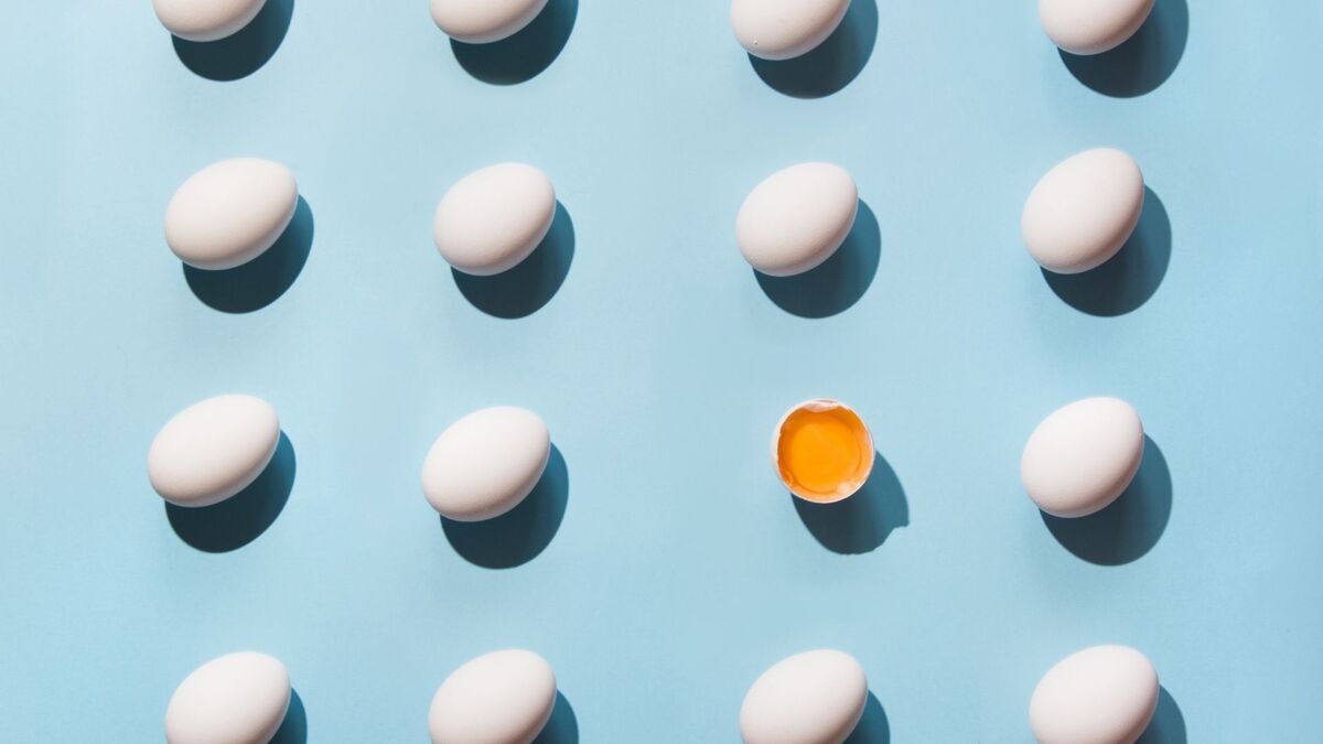 Imagem de vários ovos num fundo azul e um ovo aberto