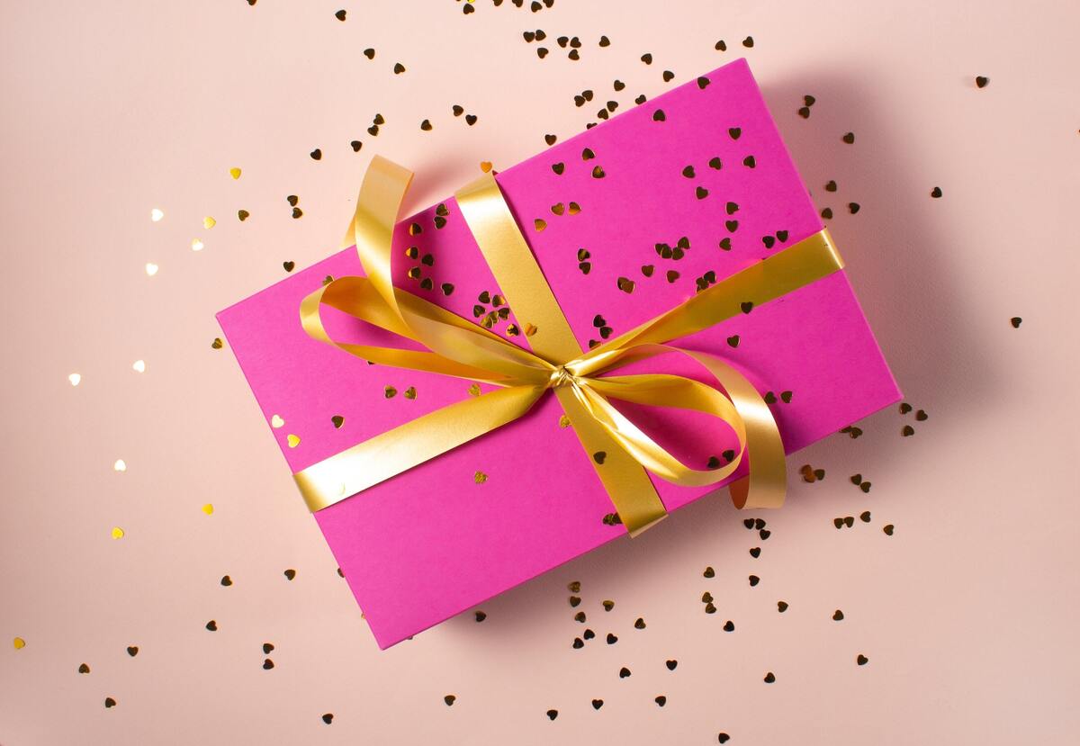 Caixa de presente rosa com fita dourada