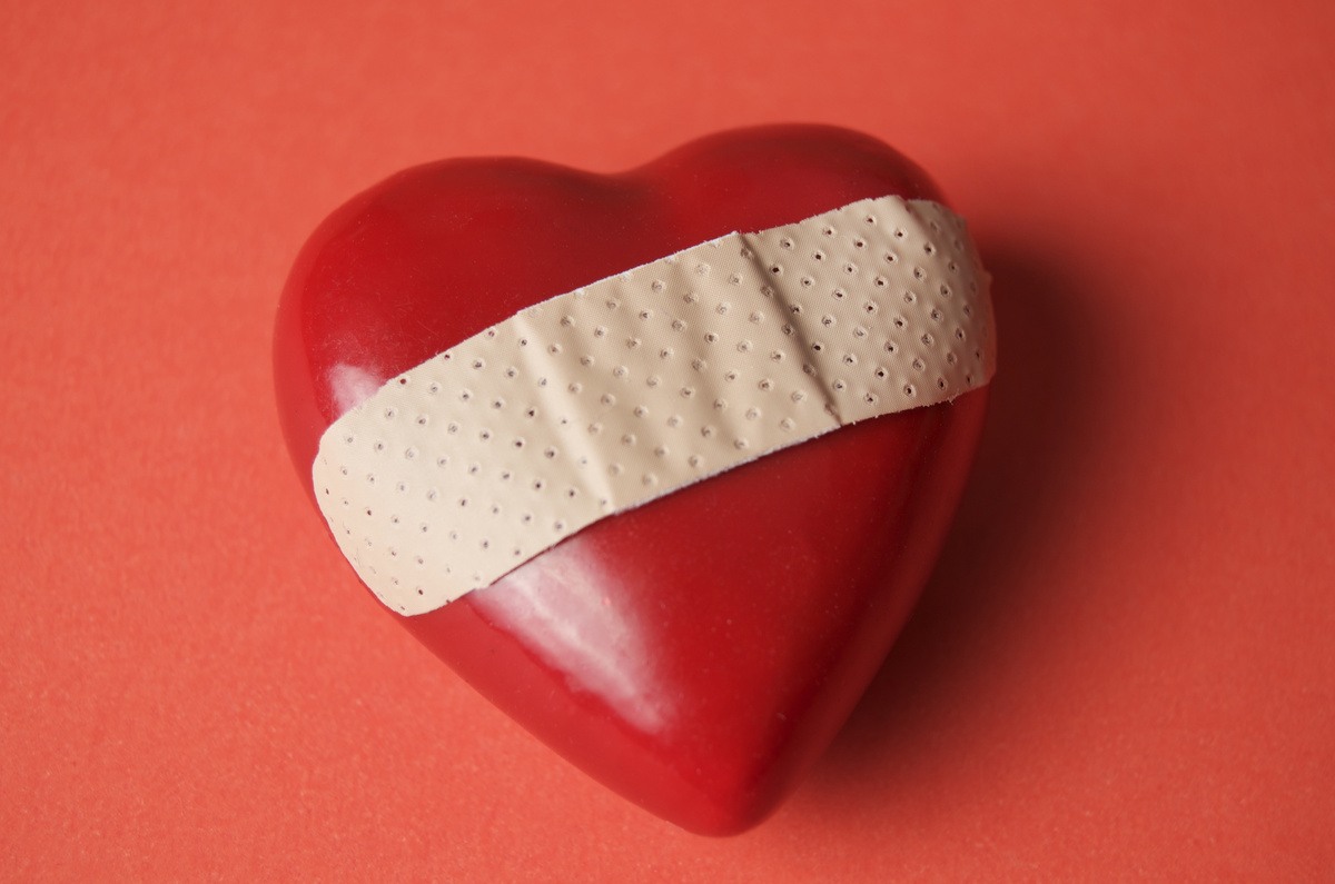 Coração vermelho com um bandaid em cima, representando os efeitos da amarração amorosa.