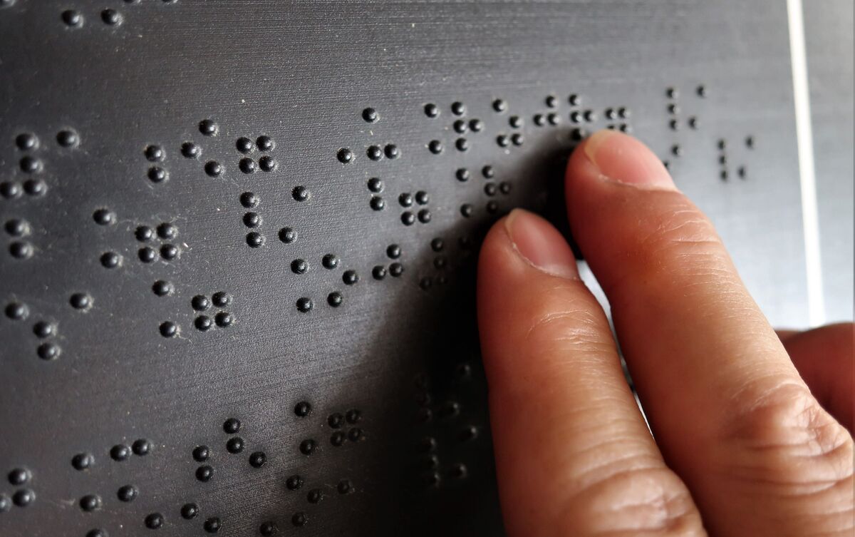 Pessoa lendo em braille.