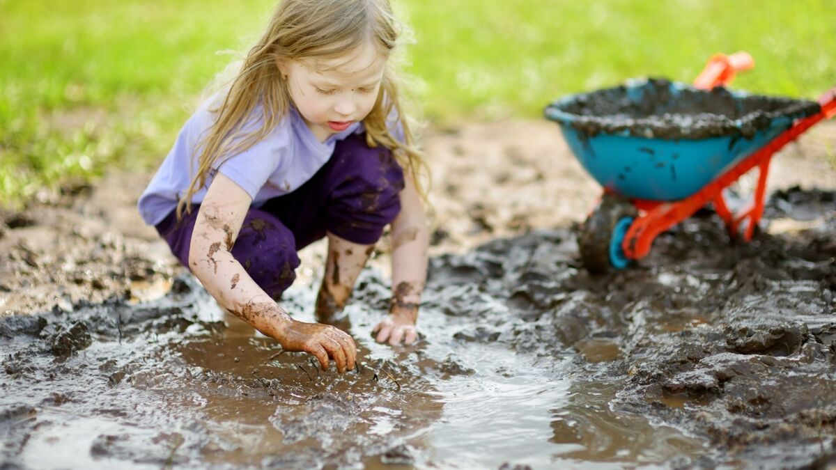 Criança brincando com água barrenta.
