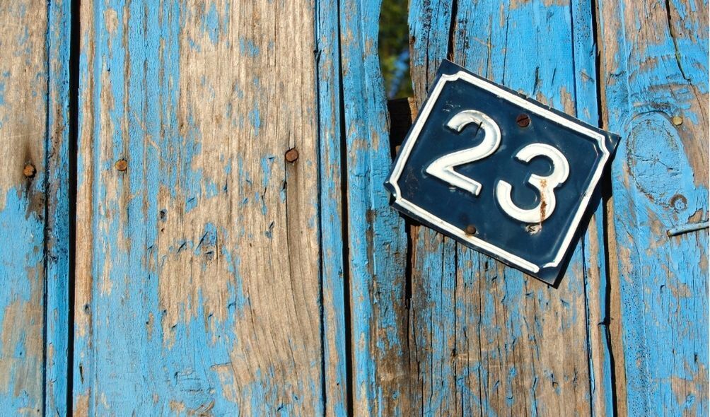Número 23 pregado em parede de madeira azul