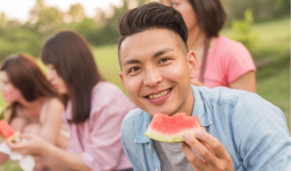 Homem japonês comendo melancia