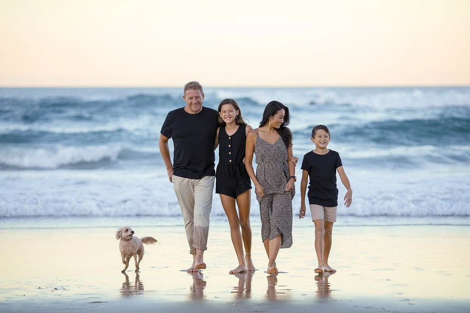 Família feliz na praia após oração pelo bem estar familiar