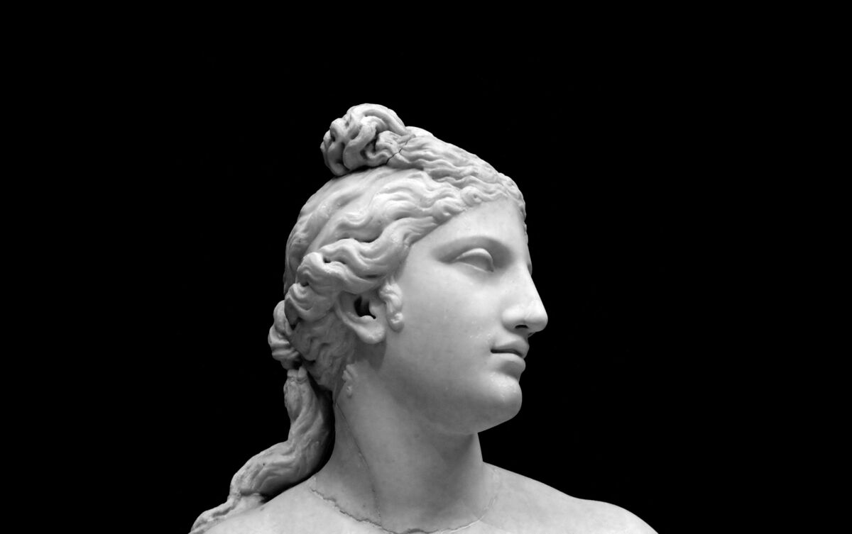 Estátua de Afrodite em fundo preto.