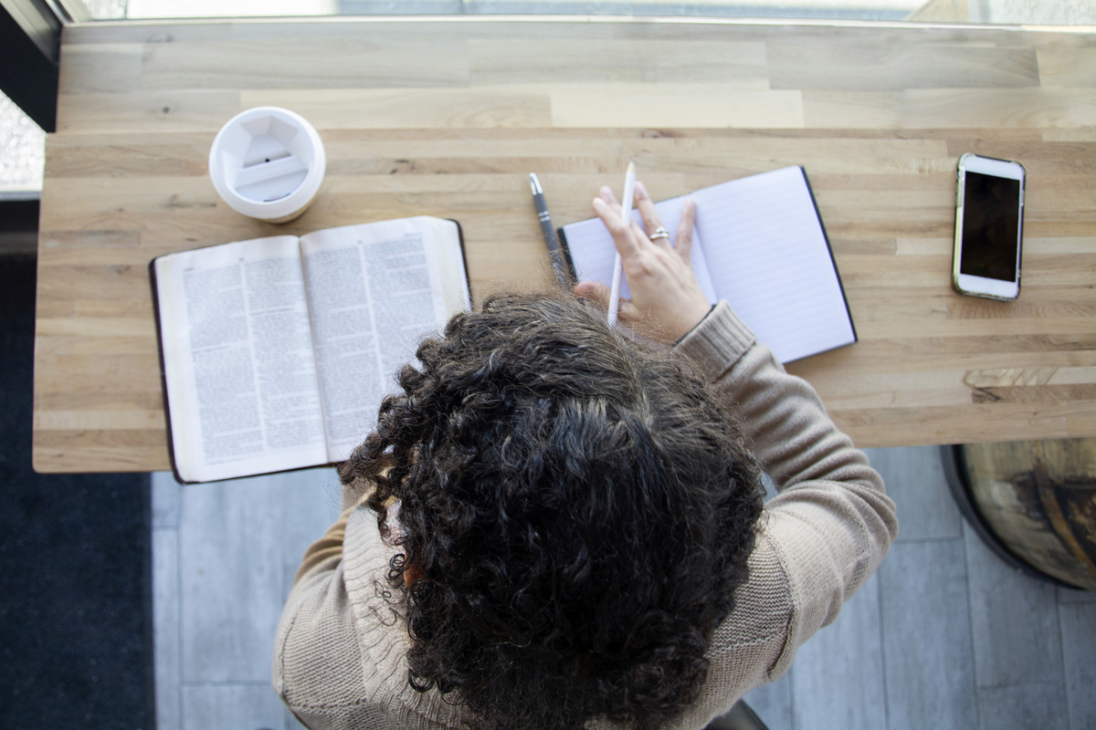 Mulher estudando com Bíblia ao lado