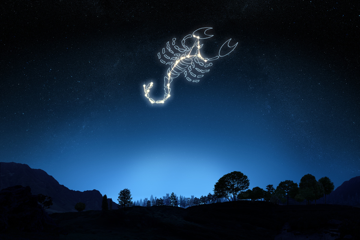 Símbolo do signo de Escorpião no céu de uma paisagem estrelada.