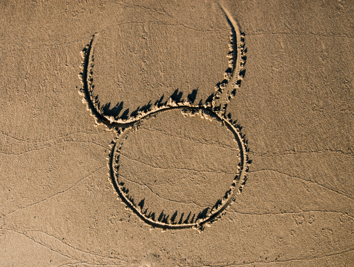 Símbolo de touro desenhado na areia da praia.