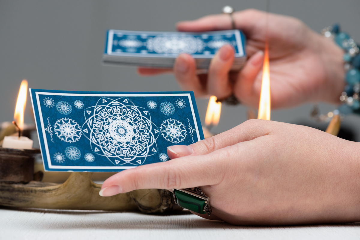 Mãos femininas segurando cartas de tarot