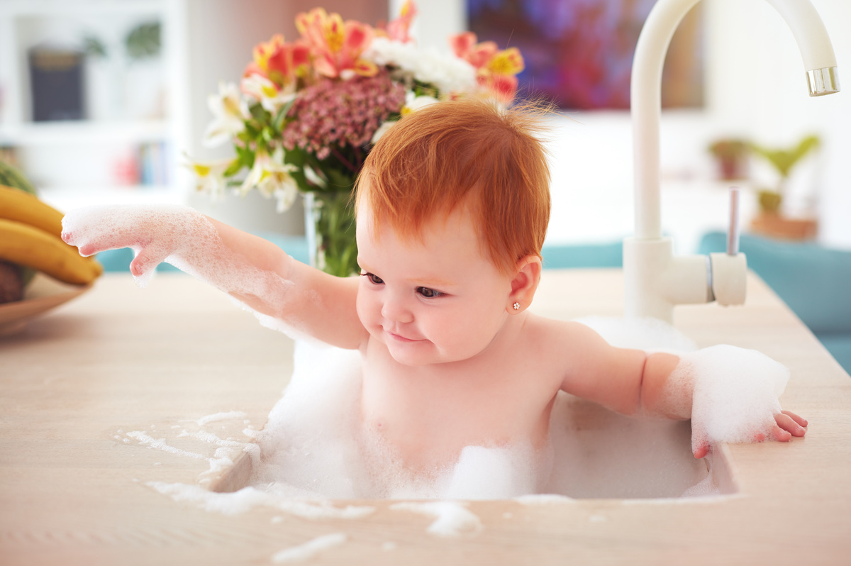 Bebê tomando banho com espuma