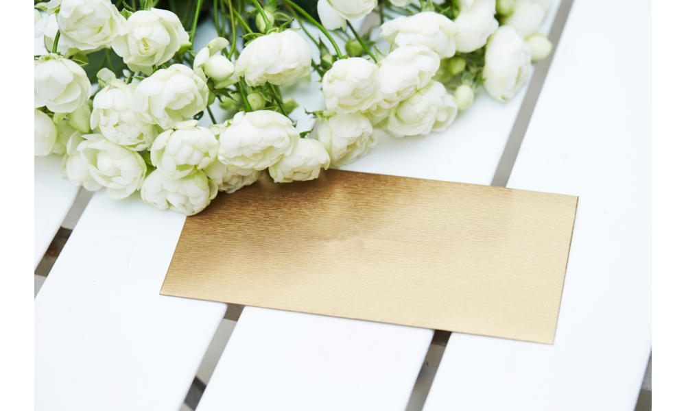 Envelope de carta em uma mesa e buquê de flores brancas ao lado