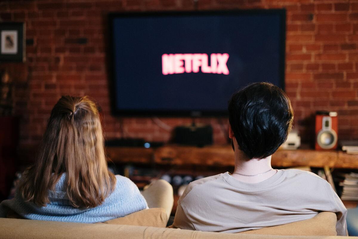 Casal assistindo Netflix na TV