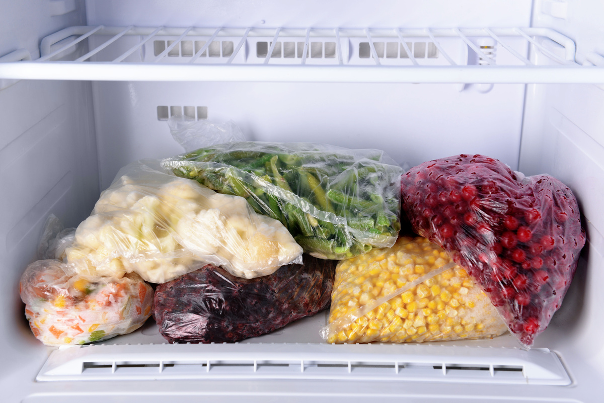 Um congeladpr abastecido com carnes e legumes