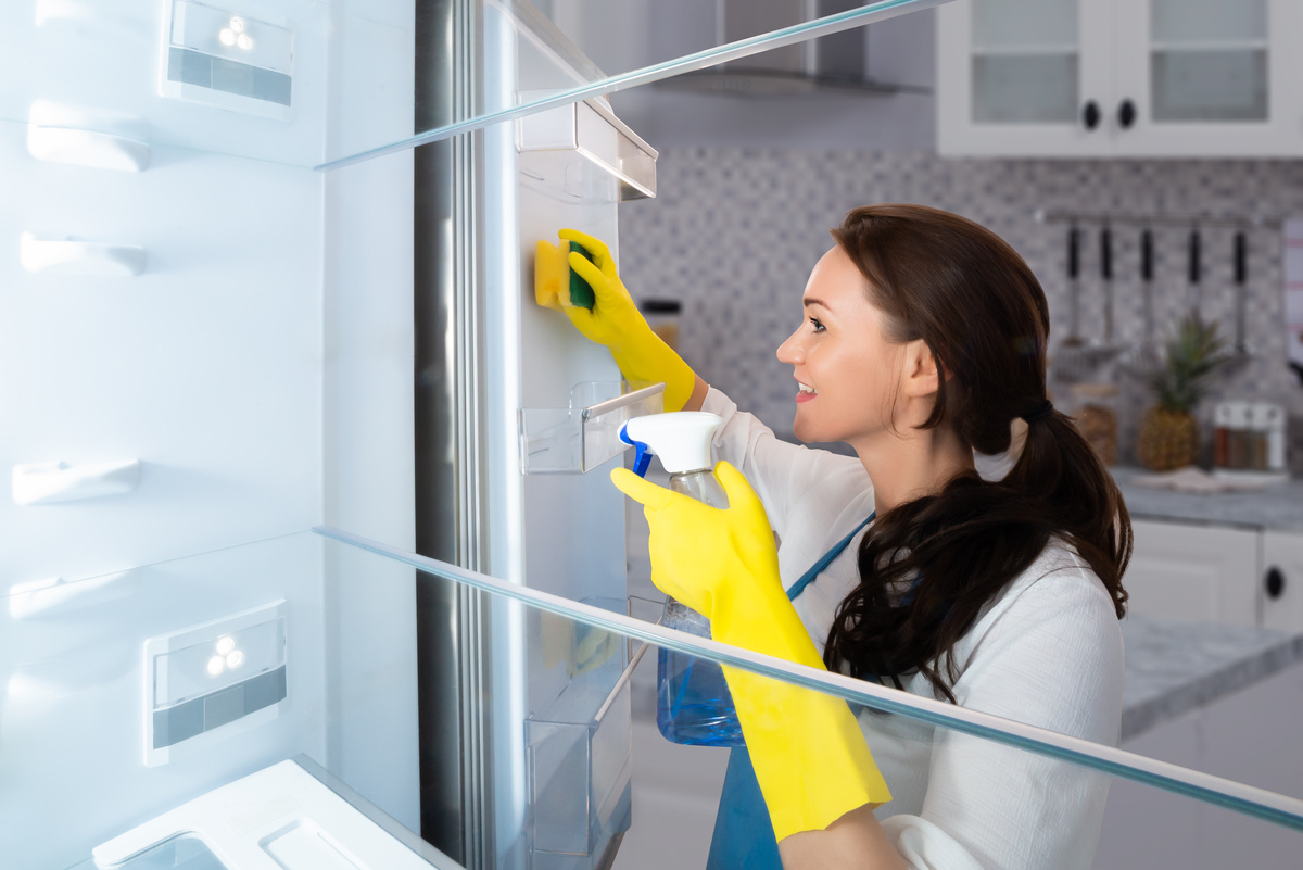 Uma mulher limpando o congelador