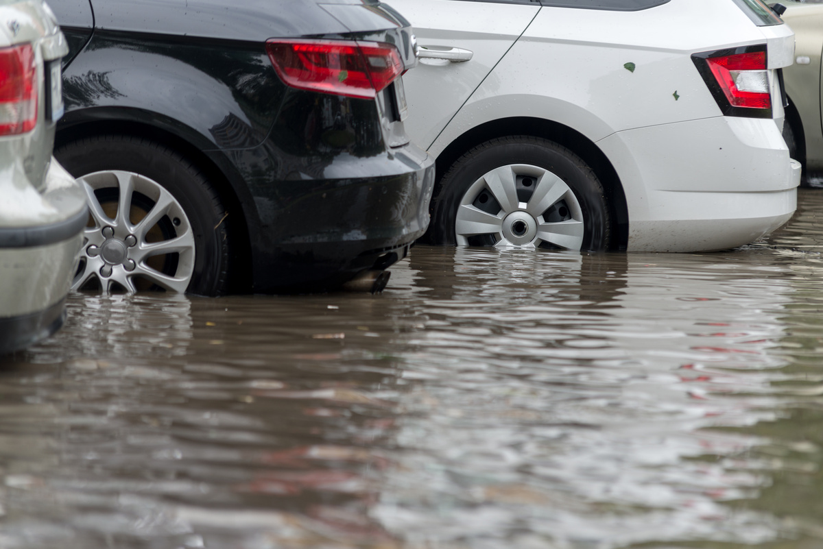 Carros estacionados em uma rua inundada por água