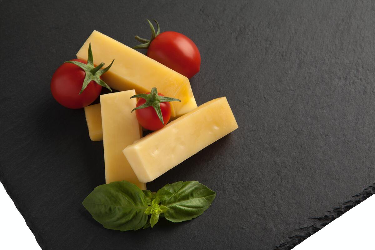 Pedaços de queijo decorados com alface e tomate.