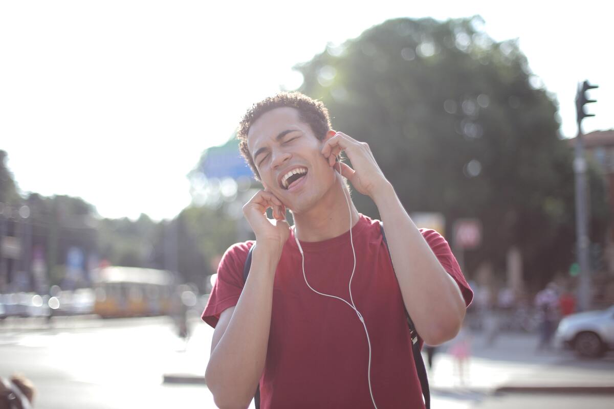 Um homem com fones nos ouvidos cantando