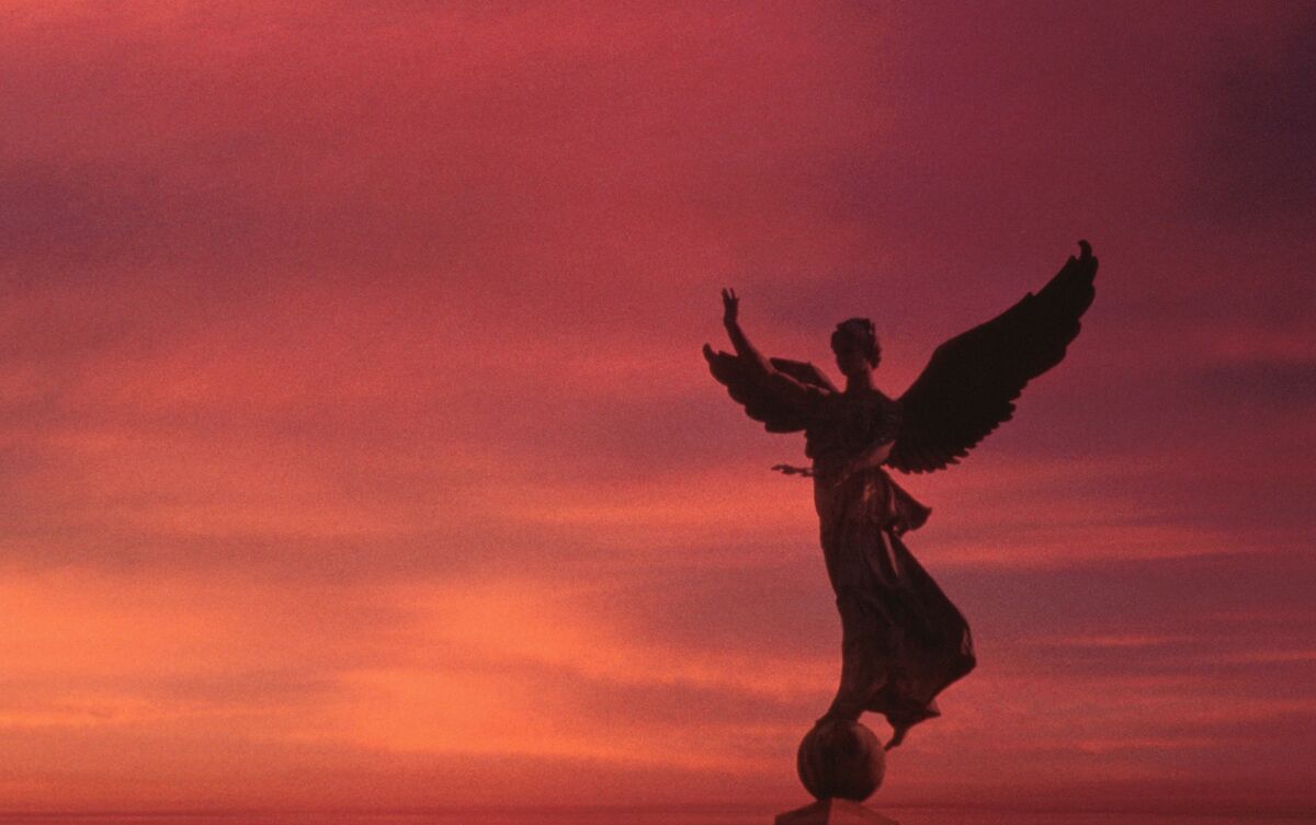 Estátua de anjo ao pôr do sol.
