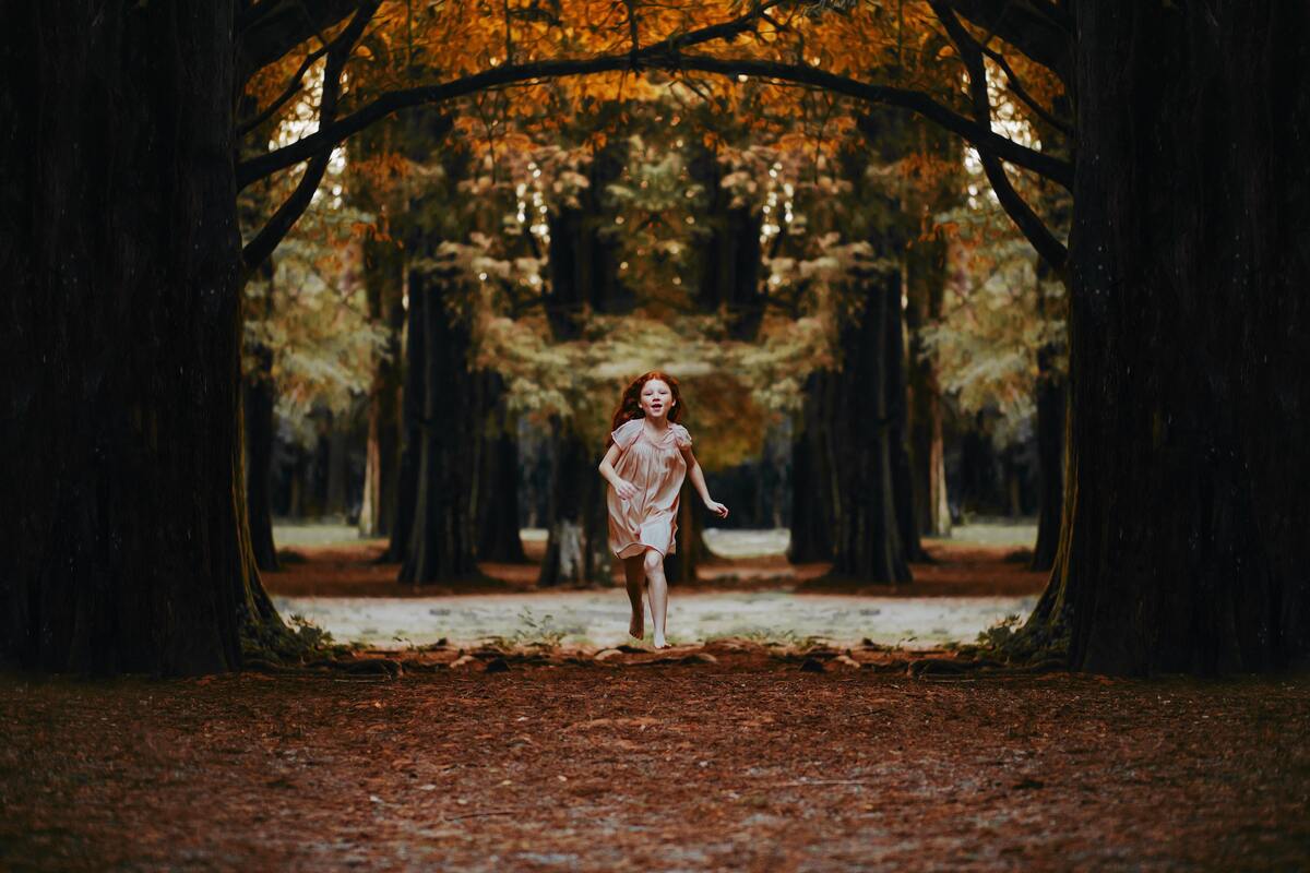 Uma menina fugindo entre as árvores