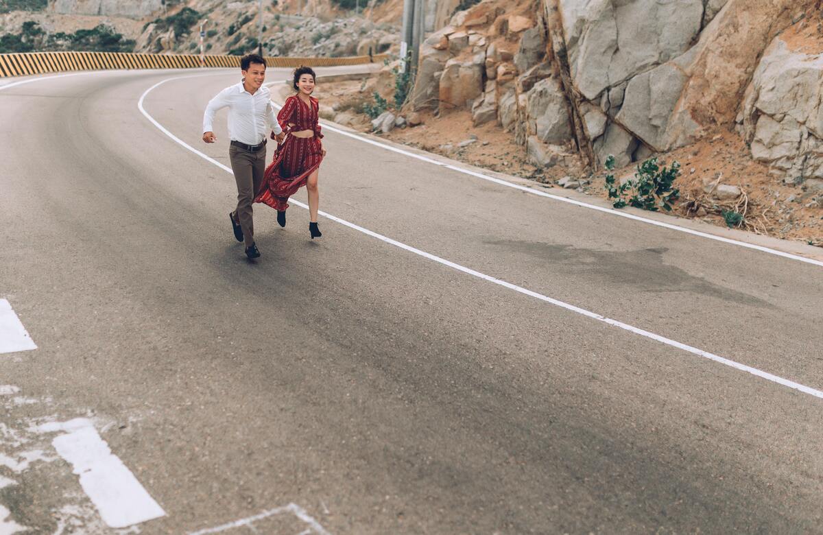 Um homem e uma mulher correndo na estrada