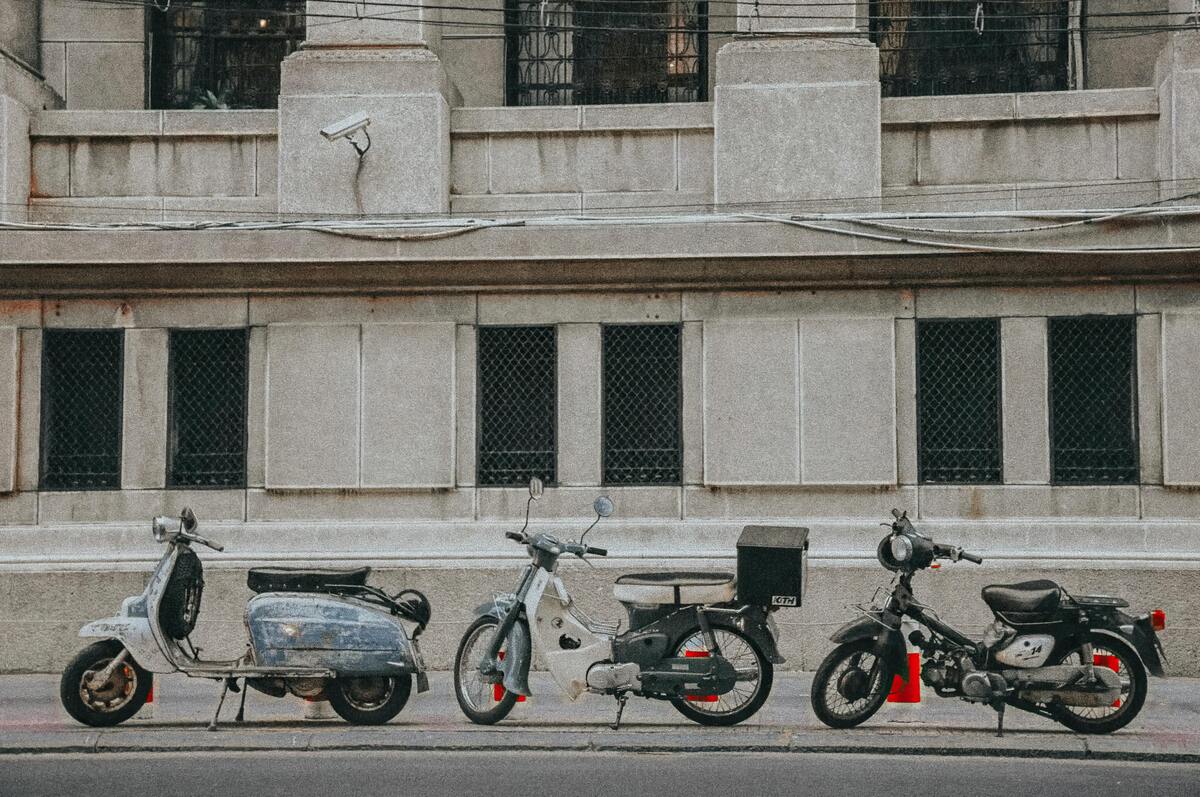 Três motos alinhadas na calçada.
